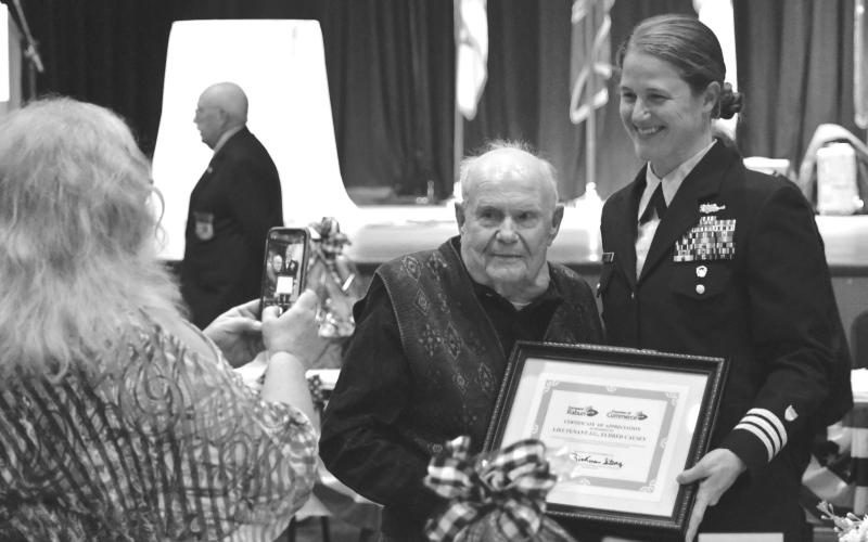 File photo. Enoch Autry/The Clayton Tribune, Kathy Causey takes a photograph of her father Eldrid Causey with Commander Sarah Ernst at the conclusion of the 24th Annual Veterans Appreciation Dinner on Nov. 9, 2023, at the Rabun County Civic Center. Ernst told the audience about Causey, then 99, who served in WWII and was the oldest veteran at the event. Causey, a Rabun County resident, died on Sept. 5, 2025, at the age of 101.