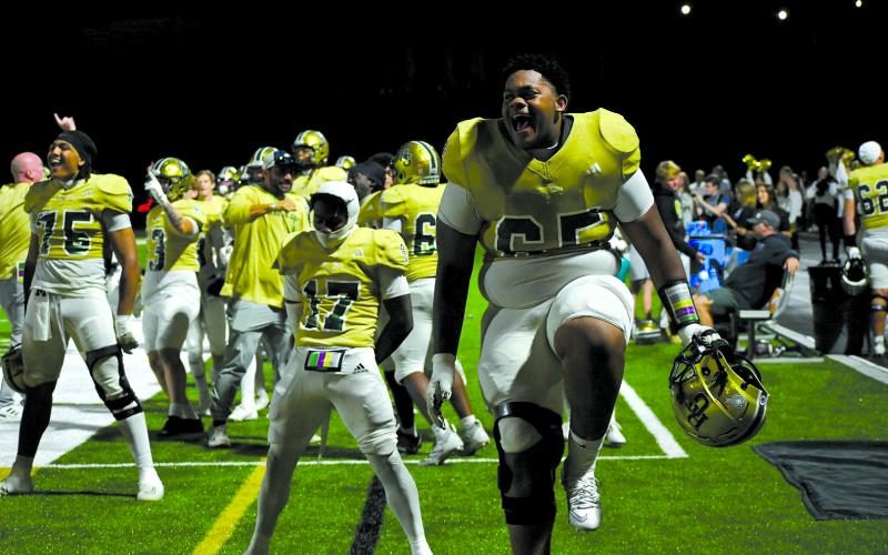 Enoch Autry/The Clayton Tribune. Devin Holly, a 323-pound offensive lineman (65), celebrates with fellow seniors receiver Joshua Burkhalter (17) and linebacker David Makonzo as teammate Elias Willingham runs a pick-six into the end zone to put Rabun Gap up 42-0 over visiting Ambassador Christian on Sept. 12. In the game, Burkhalter  caught a touchdown pass and Makonzo also had a pick-six. RGNS heads to Providence Day on Friday.