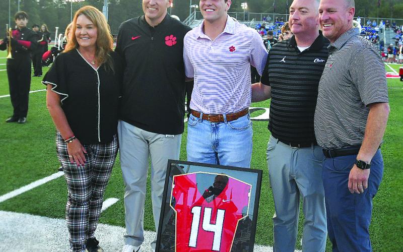 Enoch Autry/The Clayton Tribune. Gunner Stockton poses for a photo with his mother Sherrie, principal Justin Spillers, athletic director Jonathan Welch and his father Rob. Both Stocktons and Welch all won No. 14 for RCHS.