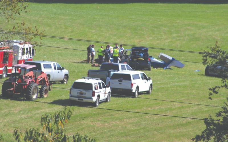 Shelby Powell/CNI News Service. Emergency personnel respond to a plane crash Thursday afternoon in a field west of Iotla Valley Elementary School. The three people aboard were killed.