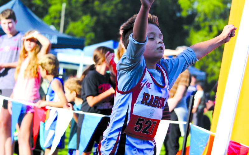 Submitted Photo. Owen Moseley as he blazes across the finish line in a scorching first place finish.