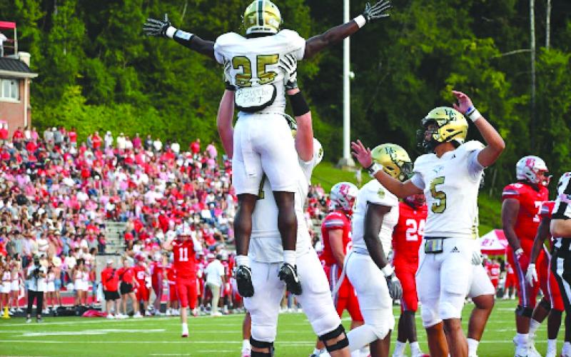 Wesley Branch/The Clayton Tribune. Rabun Gap offensive lineman Wilson Zierer lifts running back Jordan Lindo into the air in celebration after a 5-yard touchdown against Baylor on Aug. 29. The Eagles earned their first win of the season the next week at Massillon Washington High School, 50-35.