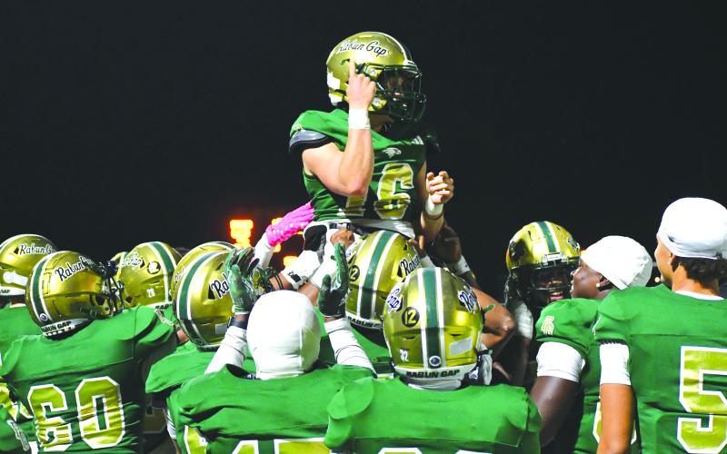 Wesley Branch/The Clayton Tribune. Rabun Gap players lift up quarterback Hector Nahle in celebration after Nahle scores a rushing touchdown versus Christ School in the Eagles’ 42-0 win over the Greenies on Oct. 17.