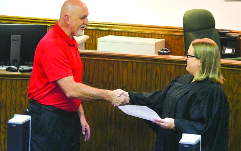 Enoch Autry/The Clayton Tribune. Newly sworn-in Mayor Roy Quilliams shakes the hand of Probate Court Judge Savannah Dixon after he took the oath on Tuesday.