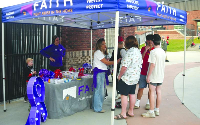Enoch Autry/The Clayton Tribune. Members of F.A.I.T.H. had a tent at the Oct. 3 football game between Rabun County and Commerce to provide people with information about awareness for domestic violence and dating violence.