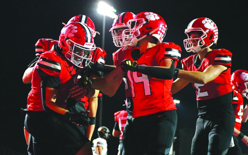 Enoch Autry/The Clayton Tribune. Senior Lake Evans (left) is congratulated by his Rabun County teammates after the running back rumbles 36 yards for a rushing touchdown in the Wildcats’ 55-28 home win over region foe Commerce.
