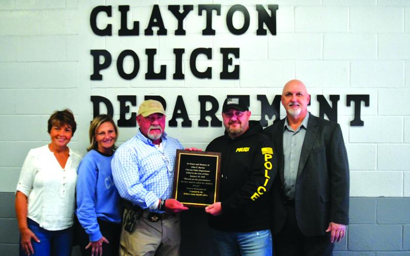 Enoch Autry/The Clayton Tribune. Tracy Crunkleton Wilson, Trudy Crunkleton, Rabun County Sheriff Mark Gerrells, Clayton Police Chief Andy Strait and Clayton Mayor pose with the plaque to honor John Burton, the Clayton police chief who was fatally shot 100 years ago. Wilson and Crunkleton, the current Clayton city manager, are the great granddaughters of Burton. Gerrells, who researched how to get Burton honored, is a former Clayton police chief.