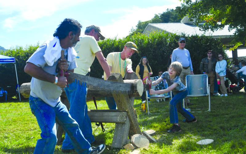 Enoch Autry/The Clayton Tribune.  Individuals took turns sawing logs at the Mountaineer Festival on Oct. 4 at the Rabun County Civic Center pavilion area.