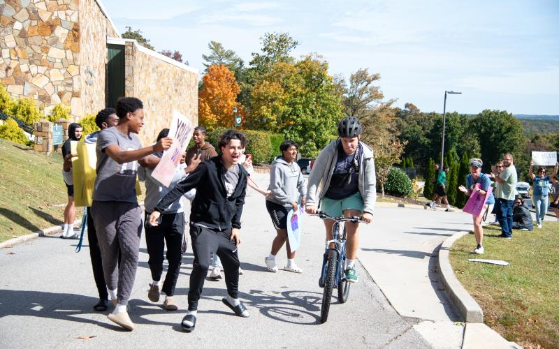 Photo/Tallulah Falls School. TFS students Waldon McInTosh, Louis Lenain and Sid Sharma, along with other students, cheer for Glad Puscasu as he finishes the 25-mile route on Saturday. Five TFS students made up the group of over 250 cyclists who took on the Twin Rivers Challenge.