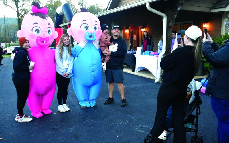 Enoch Autry/The Clayton Tribune. A number of the participants posed for photos with the oversized pink and blue babies that were at the 5K.