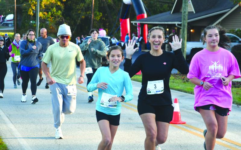 Enoch Autry/The Clayton Tribune. Eden Cullen, Suzanne Cullen and Anna Foster are happy to get the race started on a cool morning in Tiger.
