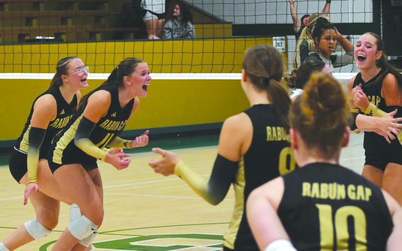 Wesley Branch/The Clayton Tribune. Rabun Gap volleyball players celebrate after the game-winning point versus Tallulah Falls School on Aug. 19. The Eagles’ 14 regular season wins are already more than the team had last season.