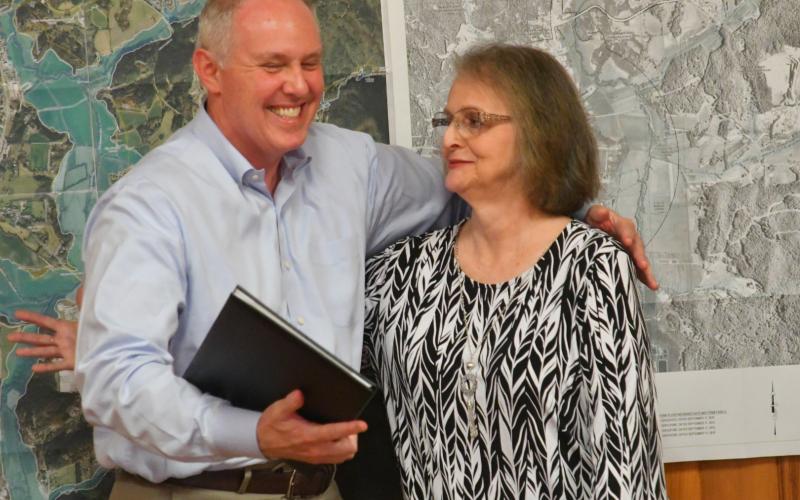 Enoch Autry/The Clayton Tribune. Rick Story hugs Glenda Enloe after Story read a resolution that was penned by Georgia State Rep. Victor Anderson.