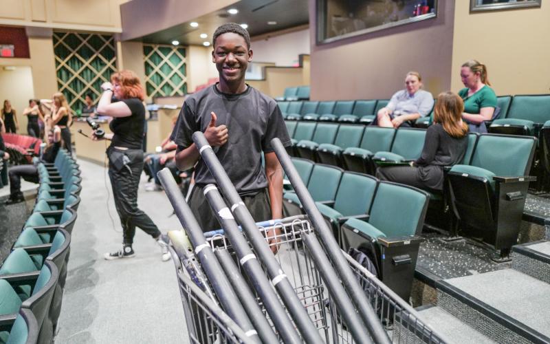 Zach Taylor/CNI News Service. Kwabena Nartey pushes a cart full of lighting connectors used to hang the numerous lights in the building.