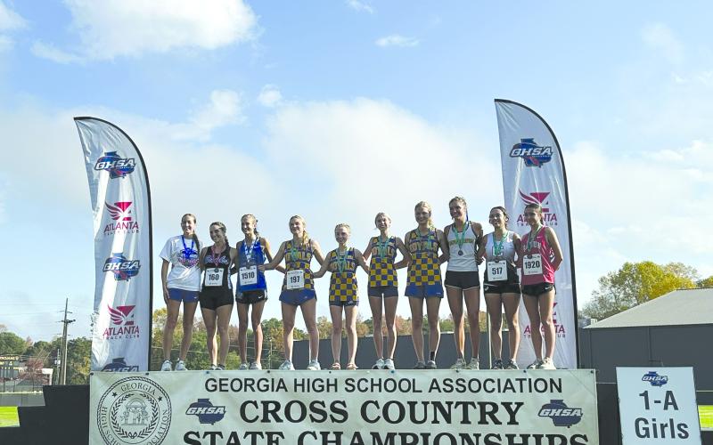 Submitted. The top 10 finishers in the Class A Division I girls state cross country race stand on the winners’ platform. Rabun County’s freshman Kinley Jones, standing on the far right, finished 10th at the meet.