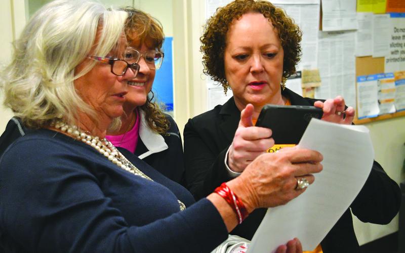 Enoch Autry/The Clayton Tribune. Newly elected mayor of Sky Valley Benita Cotton-Orr (right) takes a photo of the election results on Tuesday night at the Rabun County Elections Office in Clayton as CareySue Beasley and Beth Quarles Pence look at their winning totals as well in the Sky Valley city council race. Jesse Price also won a spot on the council.