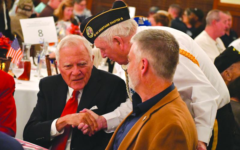 Enoch Autry/The Clayton Tribune. Doug Wayne of the Northeast Georgia Mountains Chapter 15 of Disabled American Veterans shakes the hand of former Georgia Gov. Nathan Deal at the 26th annual Veterans Appreciation Dinner at The Dillard House Resort. In the foreground is State Rep. Victor Anderson.