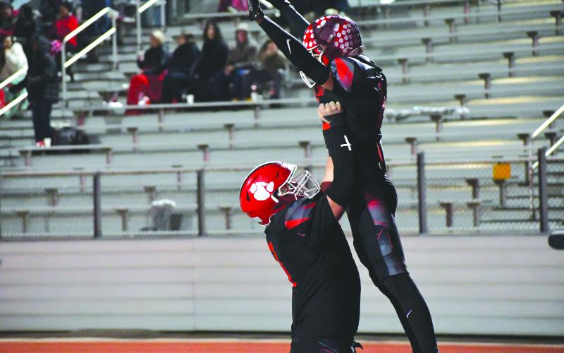 Wesley Branch/The Clayton Tribune. Rabun County offensive lineman Skylar Gunn lifts junior wide receiver Reed Lafevers in celebration after Lafevers scores his second receiving touchdown of the night in Rabun County’s 56-21 playoff win over Dodge County. The Wildcats will host Berrien on Friday, Nov. 21.