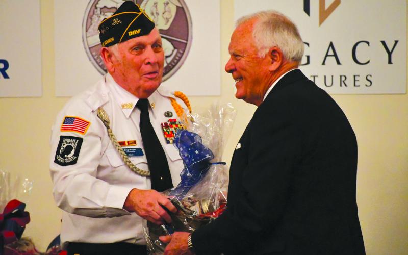 Enoch Autry/The Clayton Tribune. Doug Wayne presents former Gov. Nathan Deal with a gift basket.