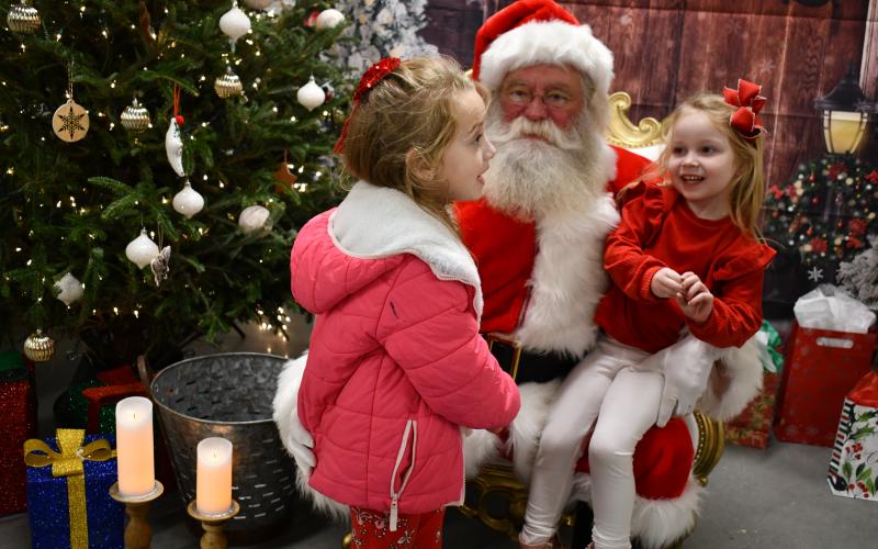 Megan Horn/The Clayton Tribune. Lyla Messer, 6; and Gentry Messer, 4, happily visit Santa “On the Farm” and tell him what they want for Christmas, during the Dec. 4 event hosted by the RCHS and RCMS FFA chapters.