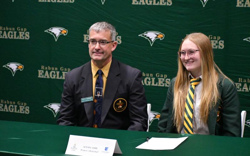 Wesley Branch/The Clayton Tribune. Rabun Gap-Nacoochee School athletic director and girls basketball head coach Dale Earnhardt (left) and Alyssa Ashe pose for a photo during Rabun Gap’s signing day festivities on Dec. 3. Ashe will be continuing her athletic and academic careers at Covenant College