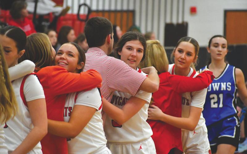 Wesley Branch/The Clayton Tribune. Rabun County seniors hug head coach DeeDee Dillard and assistant coaches Bryce Dillard and Makenna Talcott as they come off the floor in Lady Cats’ 70-16 win over Towns County on Senior Night on Dec. 9.