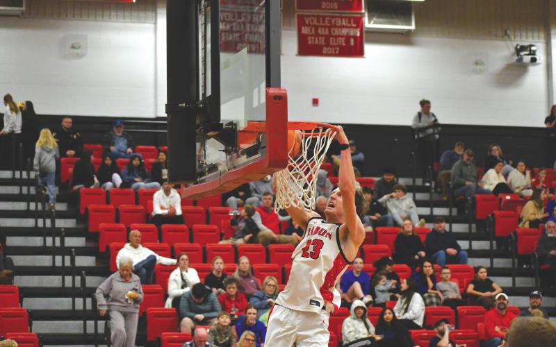 Wesley Branch/The Clayton Tribune. Rabun County senior Hayes Free hangs on the rim after a dunk versus Towns County on Senior Night on Dec. 9. Free scored 20 points and pulled down 10 rebounds in the 83-62 win for the Wildcats.