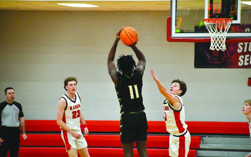 Wesley Branch/The Clayton Tribune. Rabun Gap’s RJ Lacossade lines up a potential game-tying 3-pointer with just seconds remaining on Dec. 19 versus Rabun County. Rabun County was victorious 64-59 in the game.