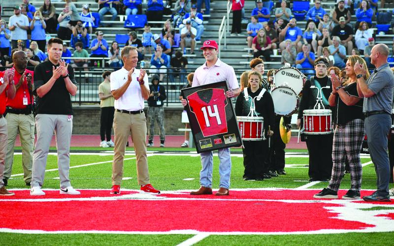 Enoch Autry/The Clayton Tribune.Former Rabun County and current UGA quarterback Gunner Stockton is honored as his Rabun County No. 14 jersey is retired on Sept. 19 at Rabun County High School. Stockton was one of the standout players to wear the No. 14, including applauding father Rob Stockton (far right).