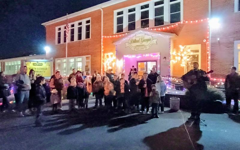 Megan Horn/The Clayton Tribune. Justin Shook, with Head of Tennessee Baptist Church, right, plays guitar and invites all the children up front. Everyone sang along to classic Christmas songs including “O Come, All Ye Faithful,” “Go Tell It On The Mountain,” and “Silent Night.”