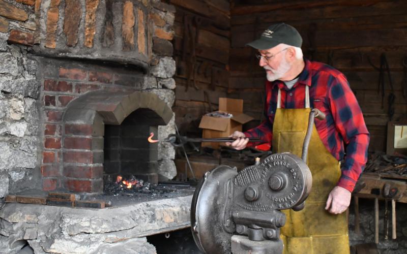 Megan Horn/The Clayton Tribune. Eric Towers demonstrates Blacksmithing for visitors to “A Foxfire Christmas” last Saturday. Joe Williams also taught and demonstrated about Blacksmithing.