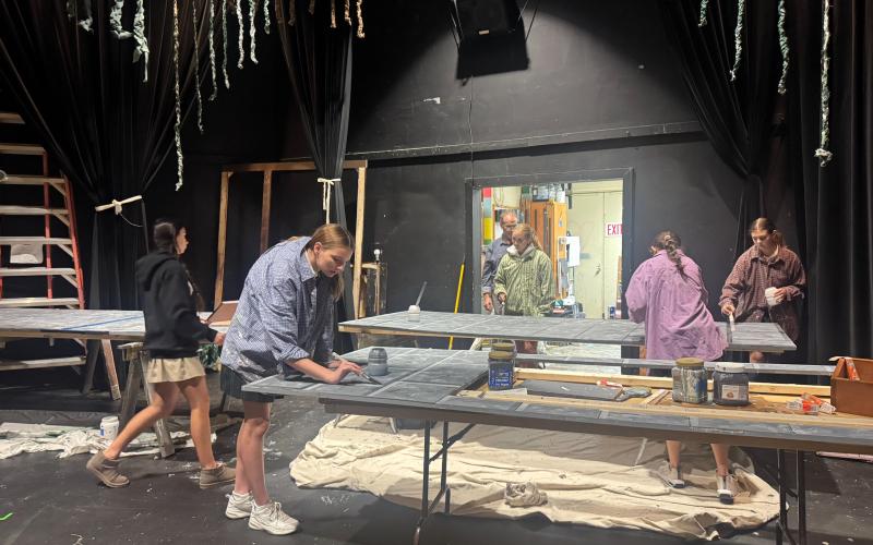 Photo courtesy TFS. Upper school students help build the set for the middle school performance.