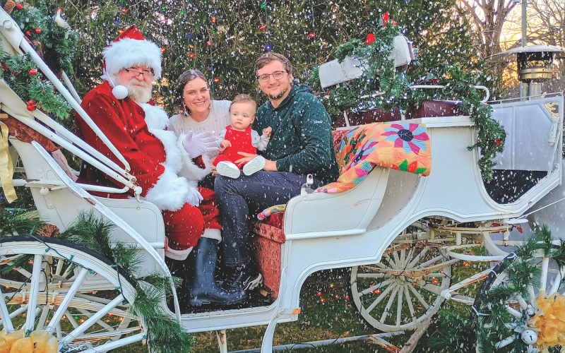 Megan Horn/The Clayton Tribune. It was a winter wonderland in Dillard Saturday, Dec. 13, at the inaugural “Dickens in Dillard” Christmas Festival. Santa, Katelyn See, Beckett See, 1, and Parker See pose on The Dillard House carriage with snow provided by Big Idea Blizzard coming down.