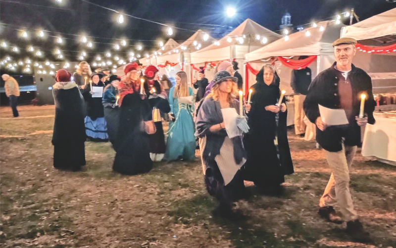 Megan Horn/The Clayton Tribune. The musical group Voices of Truth leads participants at last weekend’s inaugural “Dickens in Dillard” Festival in caroling around the Dillard City Hall Christmas tree.
