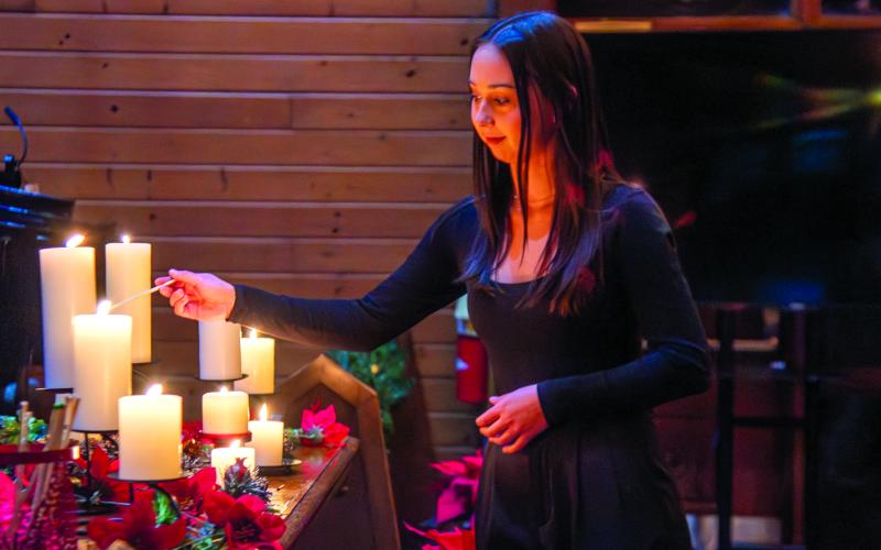 Submitted photo. Representing the senior class, Charlotte Stafford lights one of the candles at the TFS Candlelight service. Class members decide on the student who best represents their class in character and intellect.