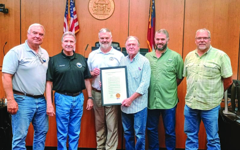 Megan Horn/The Clayton Tribune. Commissioners are presented with a resolution proclaiming Rabun County as the “Waterfall Capital of Georgia” during the July 22 Board of Commissioners meeting. Pictured are Commissioner Kent Woerner, left; Chairman Greg James; Georgia District 10 Rep. Victor Anderson; Andrew Harris, Lake Burton resident who drafted the resolution and spearheaded the designation; and Commissioners Will Nichols and Tom Garrison. Not pictured is Commissioner Scott Crane.