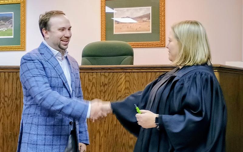 Megan Horn/The Clayton Tribune. Colt Woodall shakes the hand of Rabun County Probate Judge Savannah Dixon in her courtroom after being sworn-in as a new Clayton council member for Post 2.