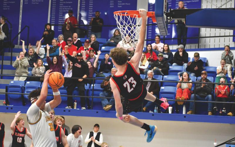 Wesley Branch/The Clayton Tribune. Rabun County senior Hayes Free hangs on the rim after a dunk versus Chesnee (S.C.) in the Battle of the States Tournament championship game on Dec. 30. Free led the way for Rabun County in the 64-59 championship win, scoring 22 points. Free also scored his 1,000 career point in the title game.
