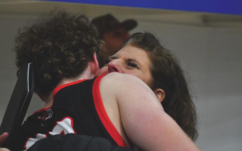 Wesley Branch/The Clayton Tribune. Rabun County senior Hayes Free hugs his mother Dena after scoring 1,000 career points in Rabun County’s 64-59 win over Chesnee (S.C.) on Dec. 30 in the Battle of the States Tournament. Free’s 1,000-point mark came in just three total seasons.