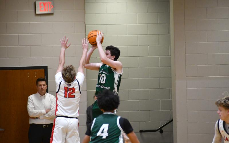 Wesley Branch/The Clayton Tribune. Rabun County’s Reed Burrell contests Athens Academy’s Bo Rentz on Rentz’s game-tying 3-point attempt with just seconds remaining in Rabun County’s 43-40 win over Athens Academy on Jan. 13. Watching the action in the background is RCHS Principal Justin Spillers.