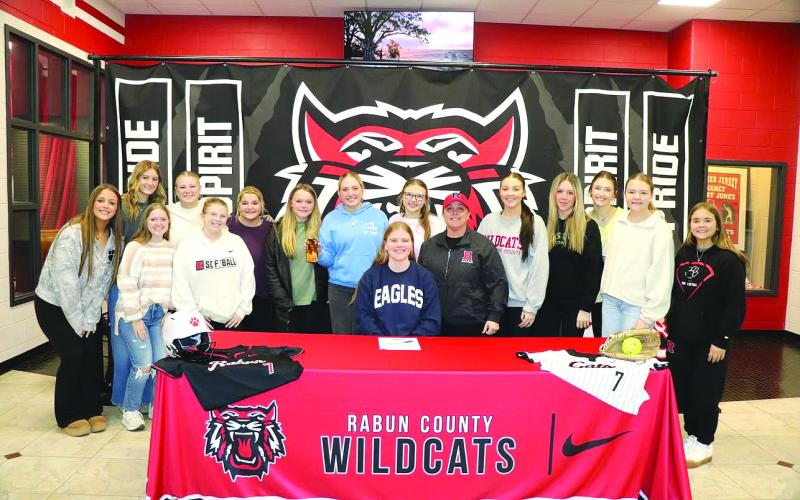 Photo courtesy of Von Watts. Rabun County senior Chloe Shirley (center) poses with Rabun County head softball coach Jessica Evans (center right) and the Rabun County softball team at Shirley’s signing day ceremony on Jan. 23. Shirley was a member of the Wildcat varsity softball team for two seasons and earned All-Region honorable mention as a senior.