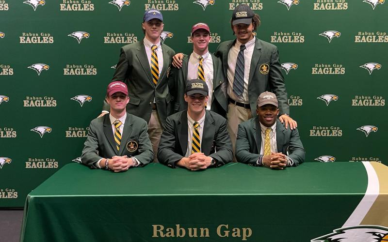 Photo courtesy RGNS. Six Rabun Gap-Nacoochee School seniors signed letters of intent on Dec. 15, 2021, to play collegiately, including Marlin Klein, who has announced his intentions to enter the NFL Draft. Five of the Eagles signed to continue their football pursuits at major-college programs, and another signed for baseball. Seated (from left) are Tucker Holloway (Virginia Tech/football), Linus Zunk (Vanderbilt/football) and Buddy Howard (Western Carolina/baseball), while standing are Klein (Michigan/footb