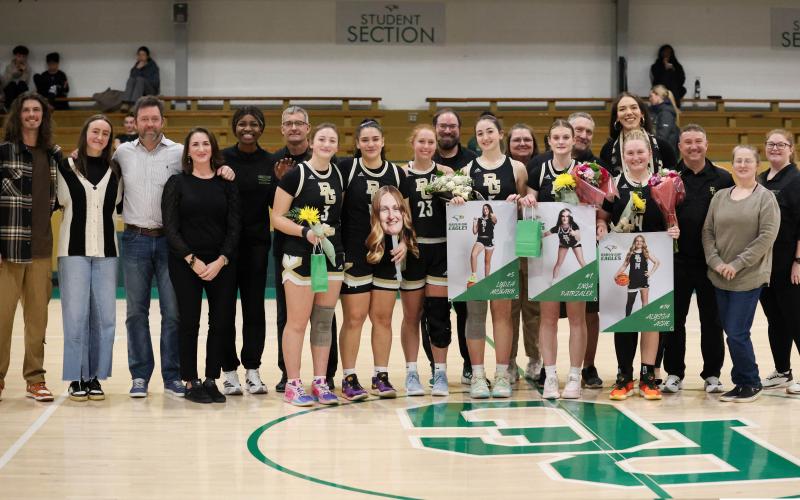 Photo courtesy Rabun Gap Athletics. Rabun Gap girls basketball seniors pose for a photo with their families and Rabun Gap girls basketball staff. The Lady Eagles seniors are 48-31 with back-to-back Final Four appearances during their time with the program.