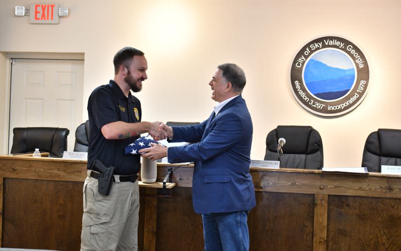 Megan Horn/The Clayton Tribune. U.S. Rep. Andrew Clyde of Georgia’s Ninth District, right, presents Sky Valley Police Officer Andrew Williams with a flag that was flown over the U.S. Capitol and a certificate designating him as a “Special Georgian of the Ninth” during a special event on Feb. 19 in Sky Valley. Williams was honored by Clyde for rescuing a couple from a Jan. 22 Sky Valley structure fire.