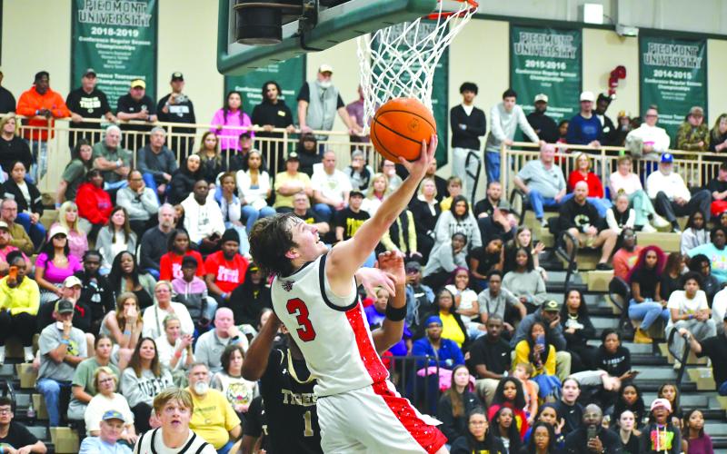 Wesley Branch/The Clayton Tribune. Rabun County senior Huey Blalock puts in a reverse layup in Rabun County’s 58-53 overtime win over Commerce on Feb. 20 at Piedmont University in the region tournament championship. Blalock led all scorers with 32 points in the game.