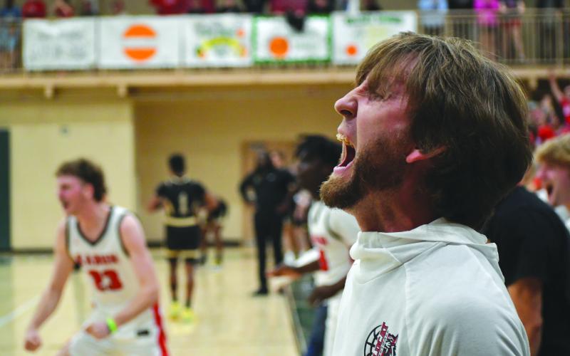 Wesley Branch/The Clayton Tribune. Rabun County Wildcat head coach David Adcock yells in celebration as the buzzer sounds in Rabun County's 58-53 overtime win over Commerce on Feb. 20 at Piedmont University to claim the region tournament championship. The win gave Rabun County back-to-back region titles for the first time in program history. RCHS also defeated Chattooga in the first round of the state tourney on Tuesday.
