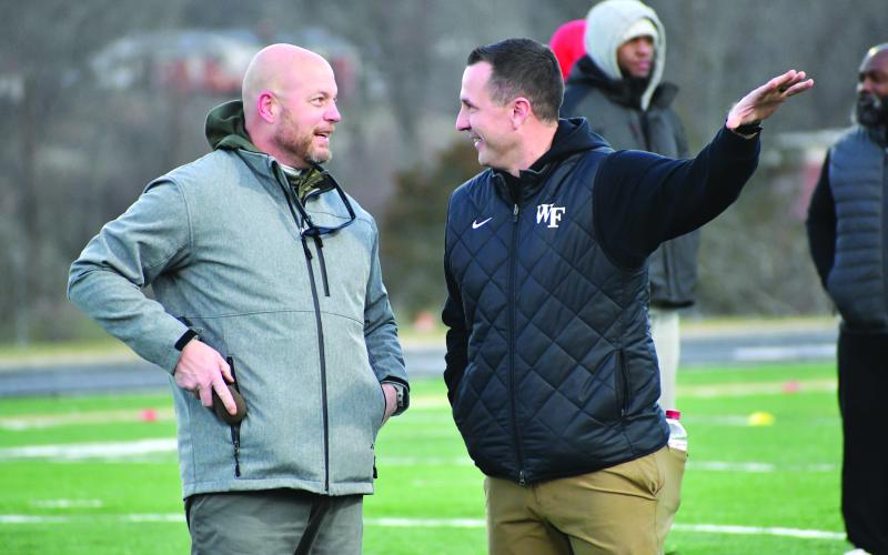 Wesley Branch/The Clayton Tribune. Rabun Gap head football coach Derek White (left) and Wake Forest head football coach Jake Dickert (right) talk during the Rabun Gap College Coaches Social on Jan. 28. Two Rabun Gap players received a scholarship offer from Wake Forest following the coaches social.