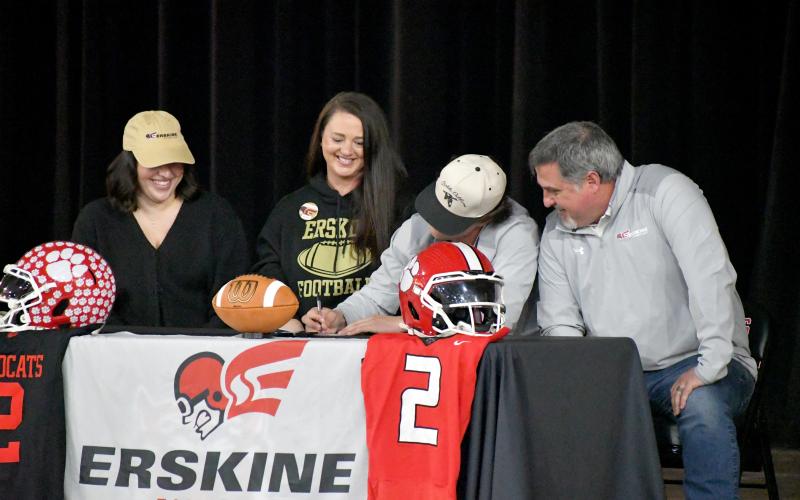 Wesley Branch/The Clayton Tribune. Rabun County football senior Ty Truelove signs his letter of intent to Erskine College with his family on Feb. 5 on Rabun County’s campus. Truelove was a 3-year starter for the Wildcat football team, totaling over 6,600 yards and 73 touchdowns in his career as a whole.