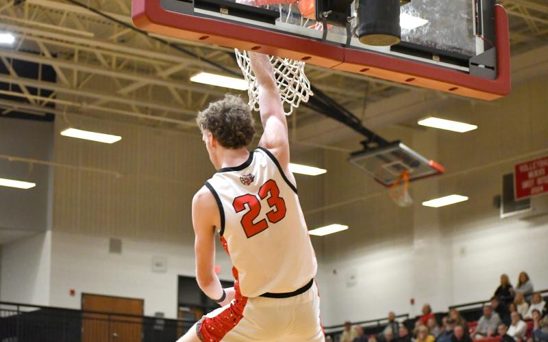 Wesley Branch/The Clayton Tribune. Rabun County senior Hayes Free hangs on the rim following a dunk in Rabun County’s 62-50 win over Commerce on Feb. 12. Free had 22 points and seven rebounds in the win.