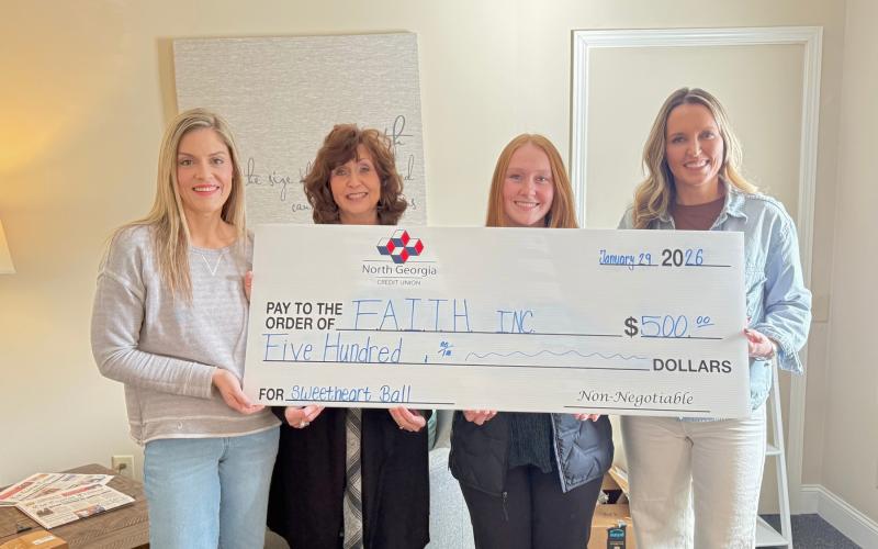 Submitted photo. North Georgia Credit Union sponsors F.A.I.T.H. Sweetheart Ball. Pictured are Kelsey Taylor, F.A.I.T.H. director of outreach services; Carrie Kuehne, Clayton assistant branch manager; Katie Fowler, member service representative and Brooke Cannon, F.A.I.T.H. CFO, displaying the $500 check.